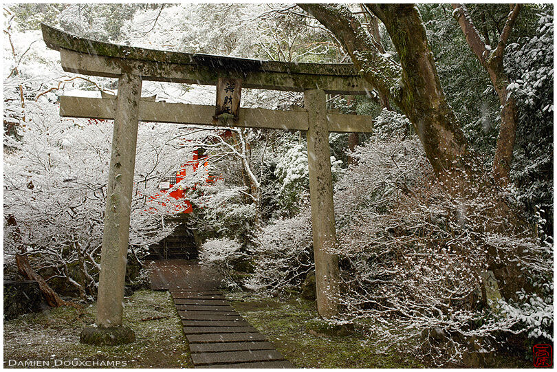 Stone torii gate on a snowy day in Bishamon-do temple, Kyoto, Japan
