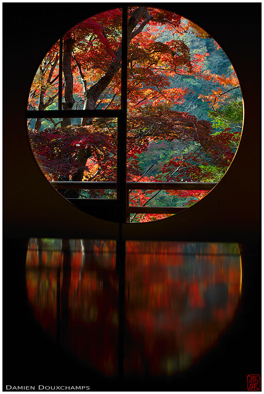 Round window with autumn reflections in Yusa-tei in the Arashiyama district of Kyoto, Japan