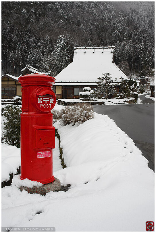 Red mail box in winter in the mountain village of Miyama, Kyoto, Japan