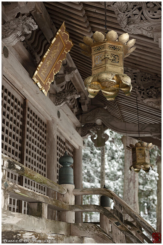 Golden lanterns and weathered wooden hall in a temple of Miyama village, Kyoto, Japan