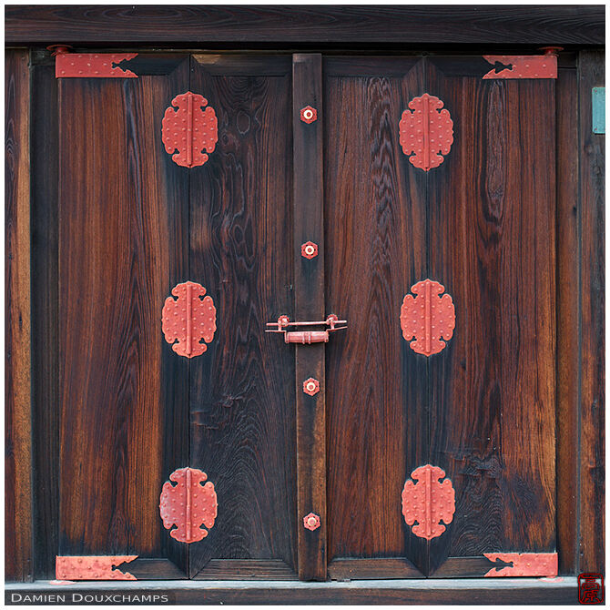 Large wooden door with red metallic fixtures, imperial palace, Kyoto, Japan