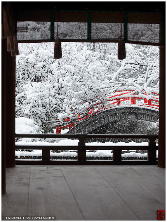 Snow covered red bridge in Shimogamo shrine, Kyoto, Japan