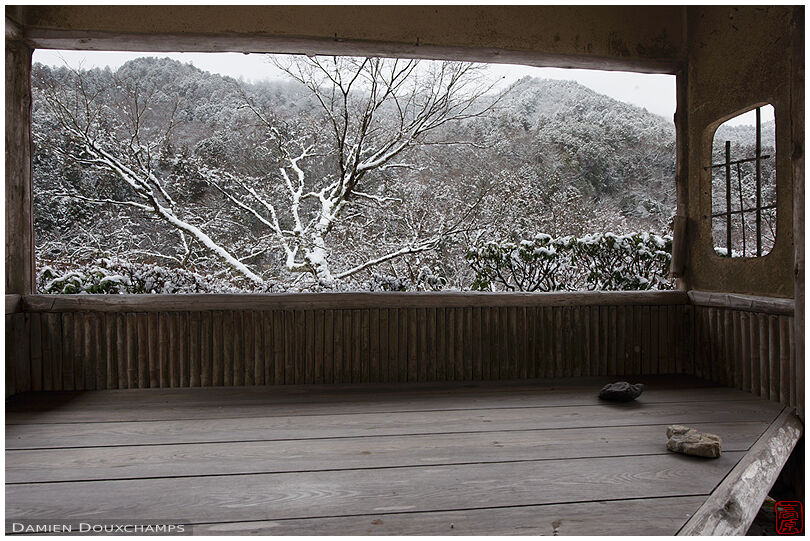 View of snow covered landscape from small pavilion in Hakuryu-en garden, Kyoto, Japan