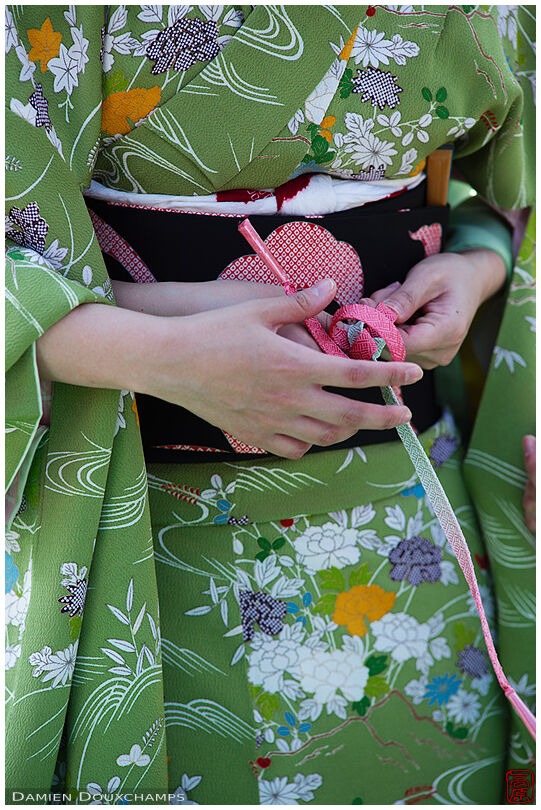 Helping hands tying the last knot of the kimono belt (obi), Jidai festival, Kyoto, Japan