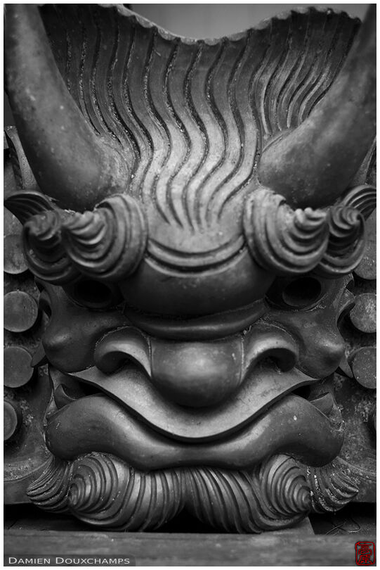 Detail of a roof tile shaped like a demon head in Soren-ji temple in the mountains north of Kyoto, Japan