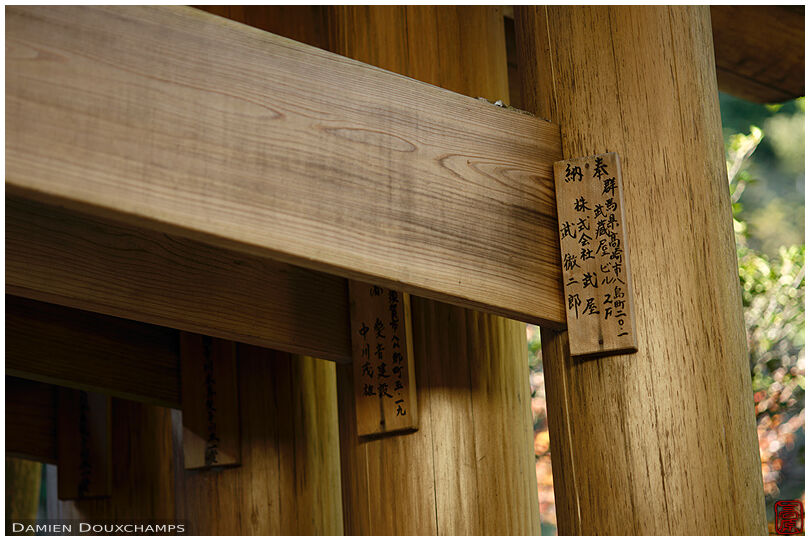 Benefactor name plate on a wooden torii gate in the Zeniarai Benzaiten shrine, Kamakura, Japan