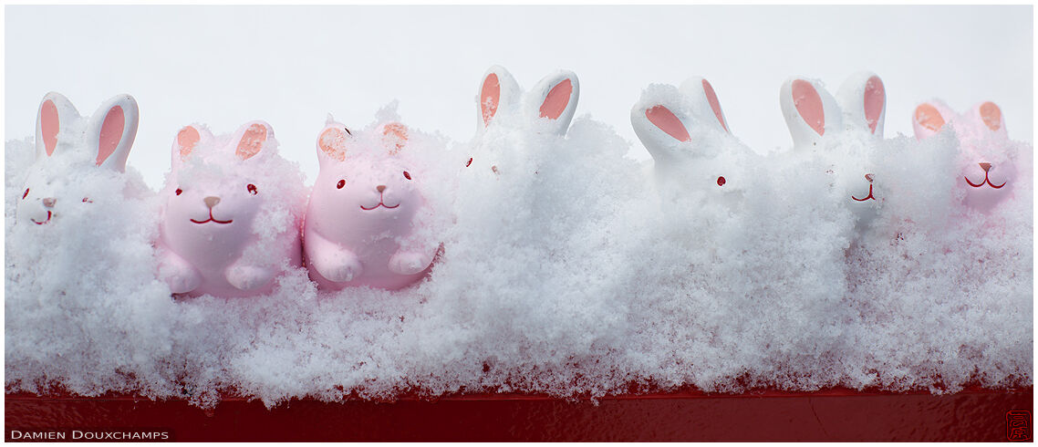 Small rabbit votive offerings lost in snow, Okazaki shrine, Kyoto, Japan