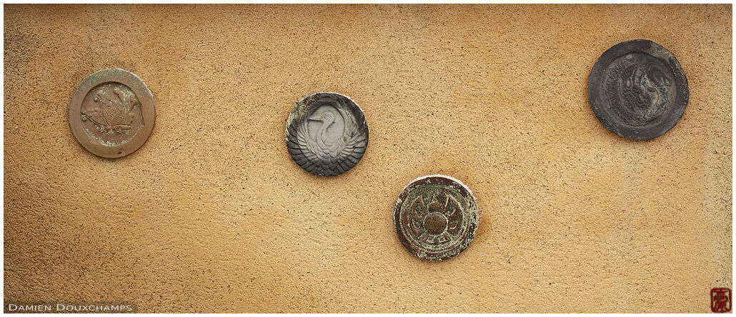 Family crests on roof tiles recycled as part of a wall in a small cemetery of Nanzen-ji temple, Kyoto, Japan