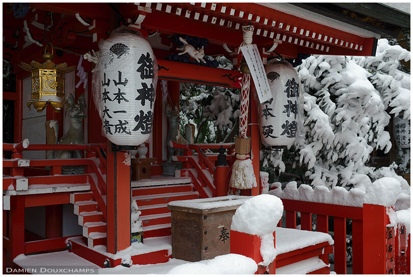 Thick snow cover on a small red shrine in Otoyo-jinja, Kyoto, Japan