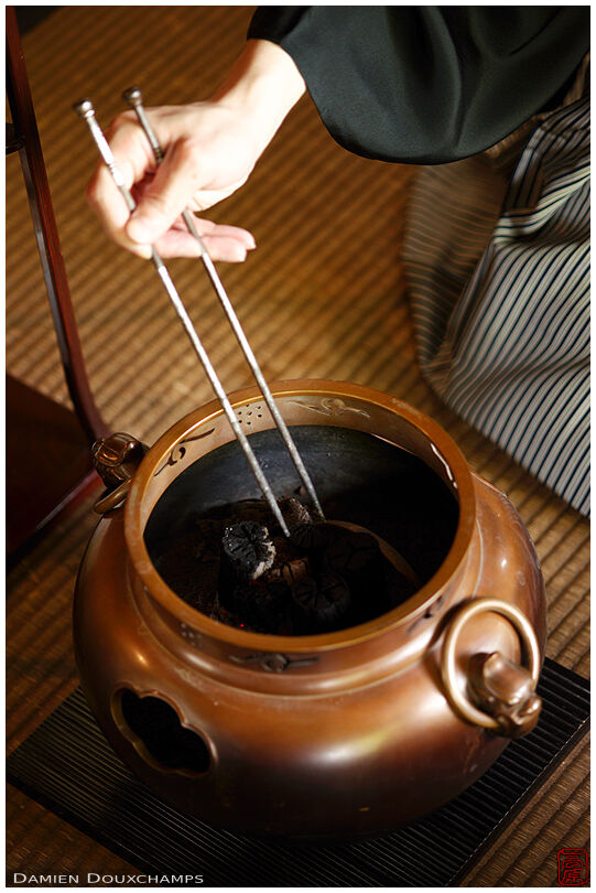 Rearranging charcoal before tea ceremony, Shodensanso, Kyoto, Japan