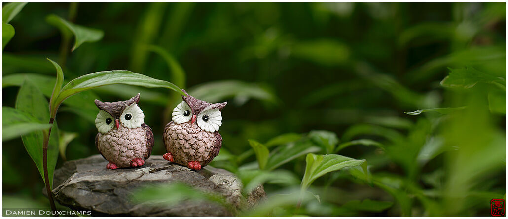 Two small owl statues in the garden of Jinzo-ji temple, Kyoto, Japan