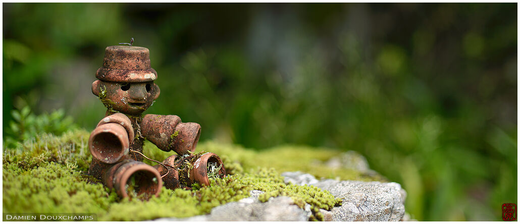 Small terracota figurine made of flower pots on the moss garden of Jinzo-ji temple, Kyoto, Japan