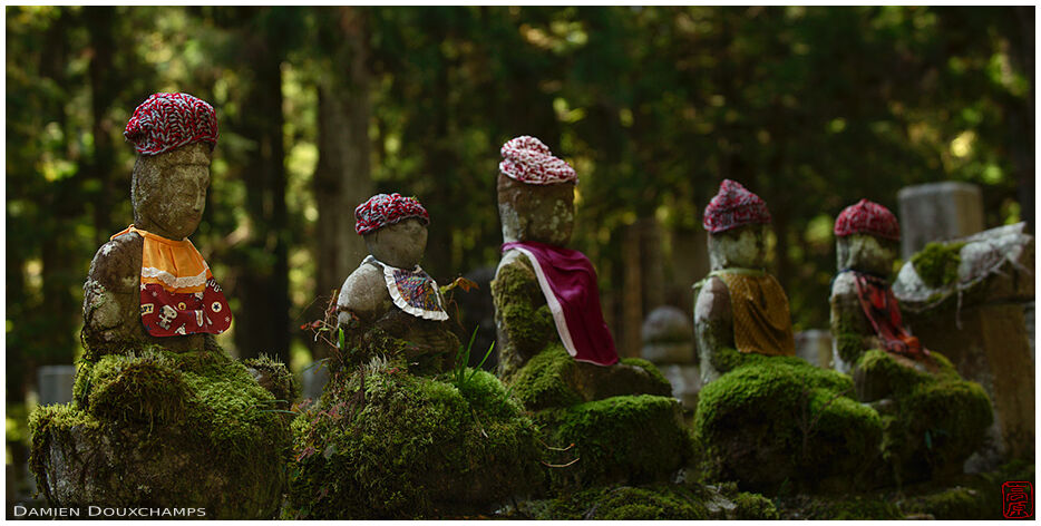 Row of old jizo statues with knit hats and bibs, Okunoin cemetery, Koyasan, Japan