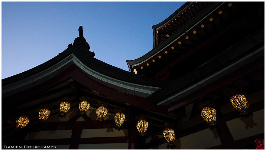 Temple roof lines and a string of lanterns at blue hour in Jofuku-ji, Koyasan, Japan
