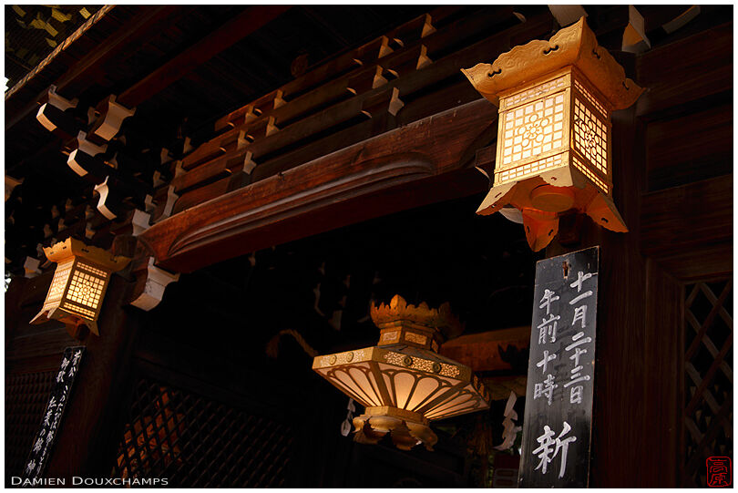 Three golden lanterns on the entrance gate of Kitano Tenmangu shrine, Kyoto, Japan