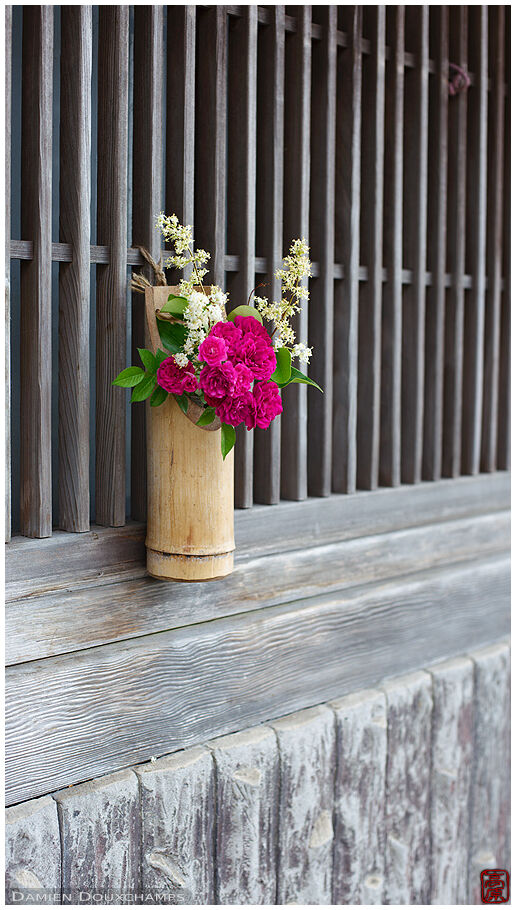 Flower bouquet hanging to traditional wooden facade near Hase-dera temple, Kamakura, Japan