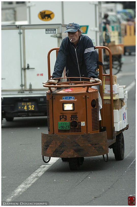 Old man riding on a toretto in Tokyo's fresh food market, also known as Tsukiji