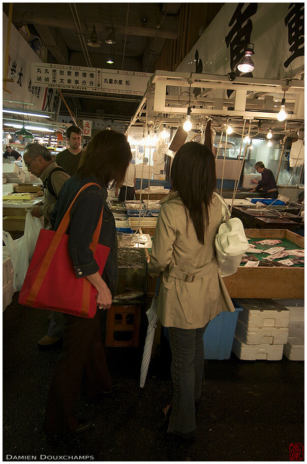 Women buying fish at Tsukiji market, Tokyo