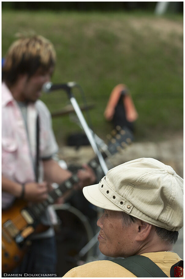 Old lady listening to a rock concert in Osakajoo koen