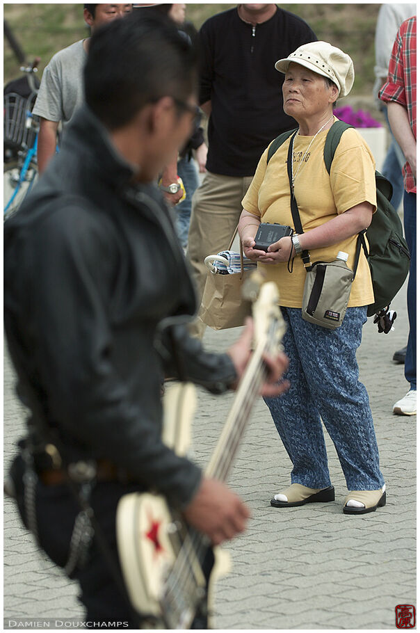 Old lady listening to a rock band